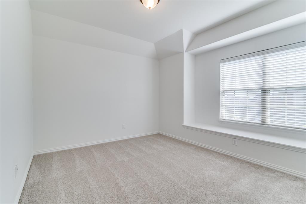 1215 Hundgate Way Forney, TX 75126 - Photo 31 of 38 Upstairs bedroom #3 with light carpet and vaulted ceilingand a window seat