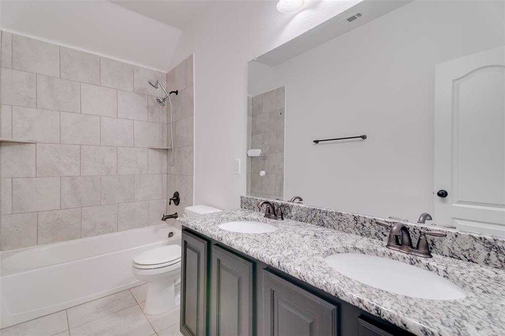1215 Hundgate Way Forney, TX 75126 - Photo 33 of 38 Full bath with double vanity, bathtub / shower combination, and light tile patterned flooring