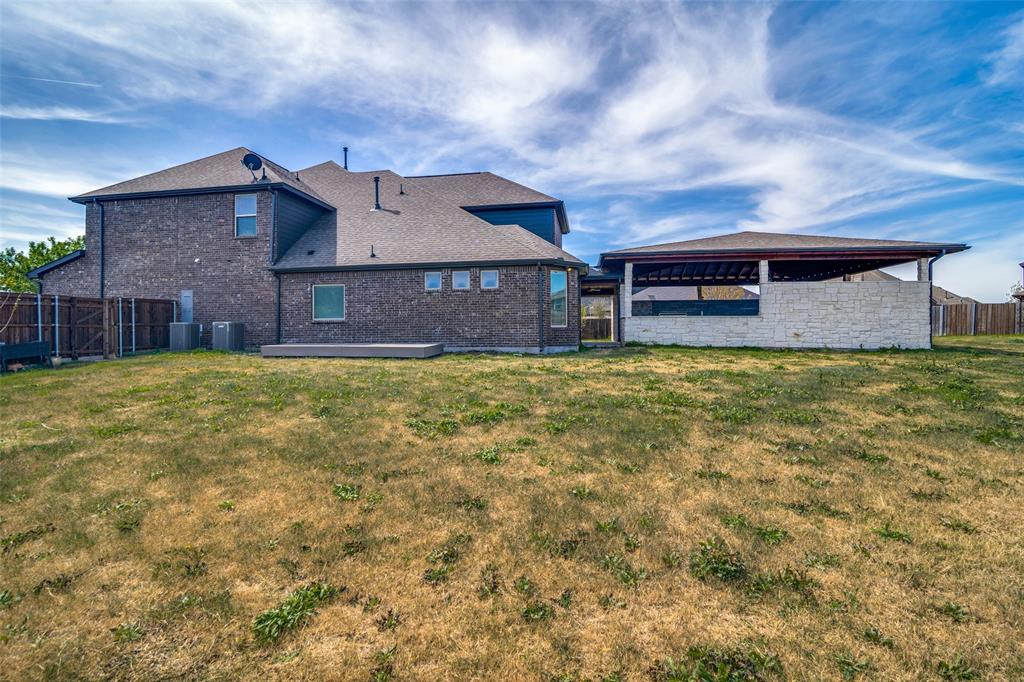 1215 Hundgate Way Forney, TX 75126 - Photo 4 of 38 Back side of house with a fenced backyard, an outdoor living space, and large yard