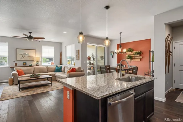 a kitchen with granite countertop a stove and living room view