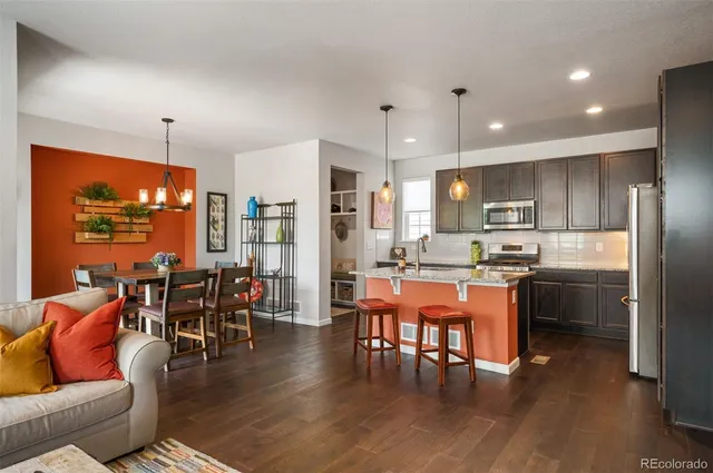 a dining room with stainless steel appliances kitchen island granite countertop a dining table chairs and view living room