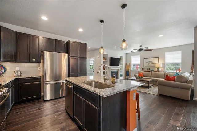 a kitchen with stainless steel appliances granite countertop a refrigerator a stove a sink and a refrigerator