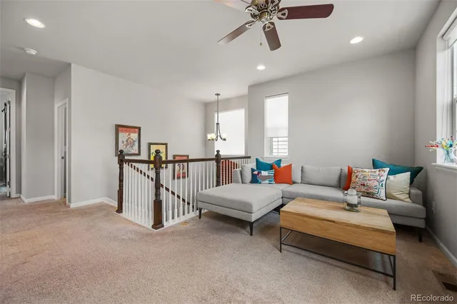 a living room with furniture and a ceiling fan