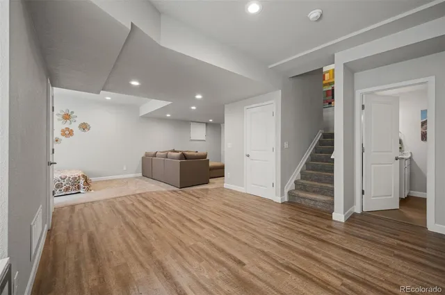 a view of a kitchen with wooden floor and staircase
