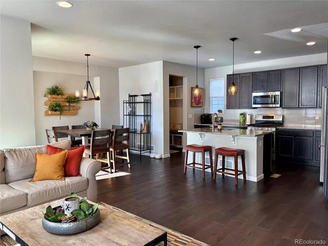 a living room kitchen with furniture and a wooden floor