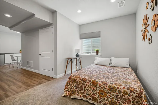 a bedroom with a large bed and a wooden floor
