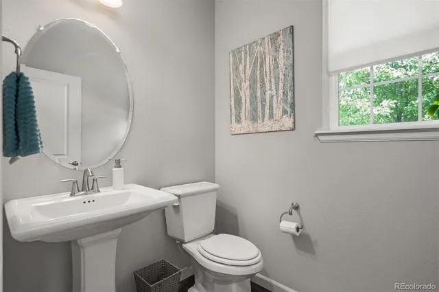 a bathroom with a toilet a sink and mirror