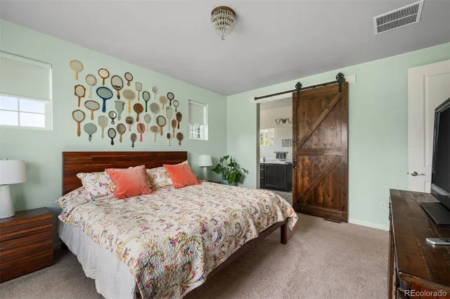 a bedroom with a large bed and a flat tv screen