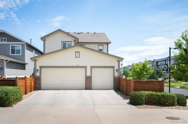 a view of a white house with a yard and plants