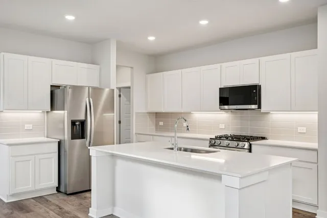a kitchen with stainless steel appliances a refrigerator sink and microwave