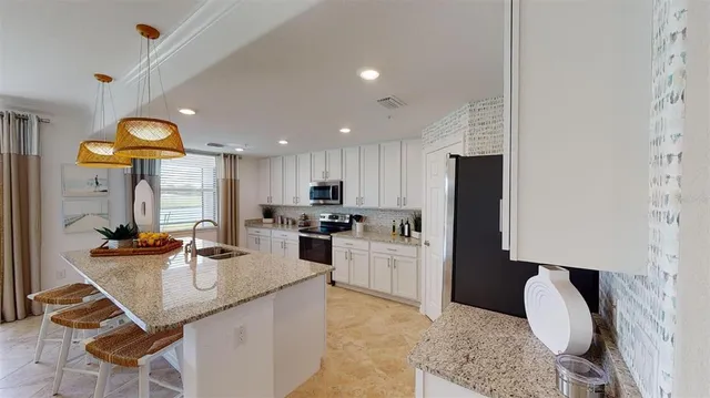 a kitchen with stainless steel appliances kitchen island granite countertop a sink and cabinets