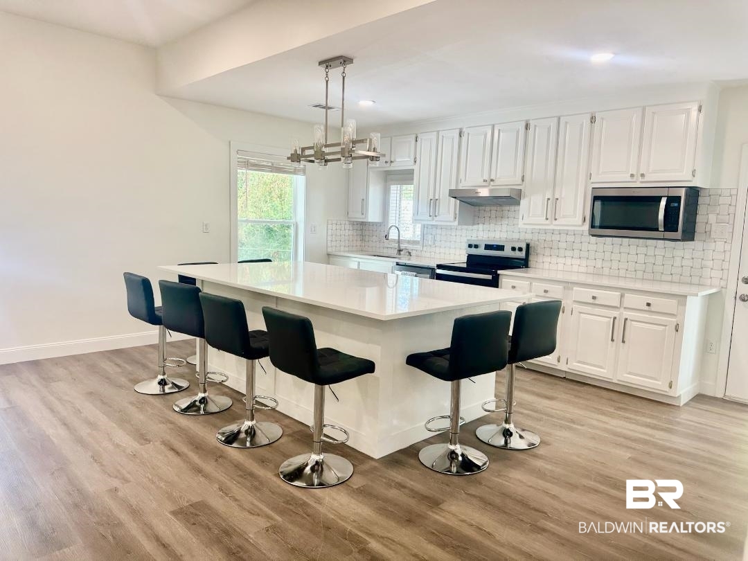 2663 Demetropolis Road Mobile, AL 36693 - Photo 11 of 26 Kitchen with stainless steel appliances, under cabinet range hood, light countertops, light wood-style floors, and recessed lighting