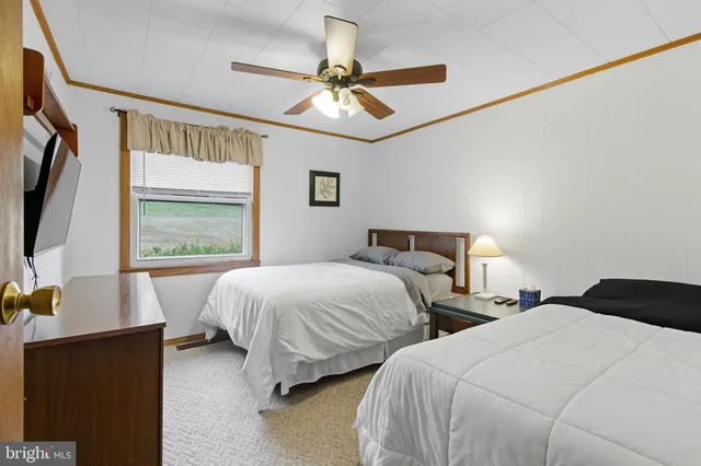 a bedroom with two beds and a flat screen tv