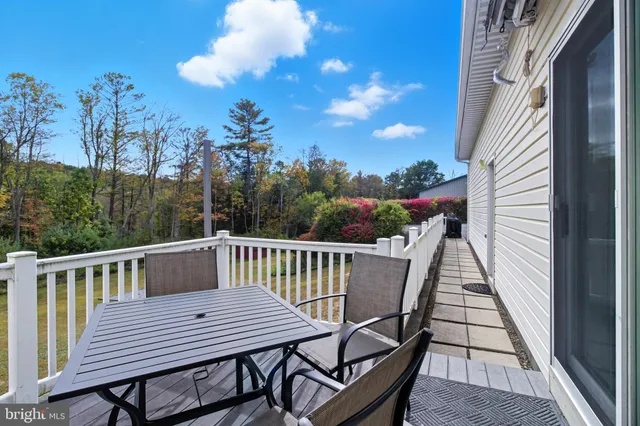 a view of a balcony with wooden floor and outdoor seating
