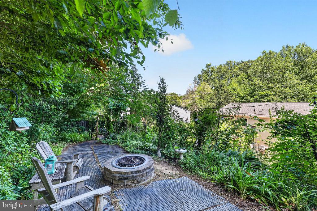 8471 Great Lake Lane Springfield, VA 22153 - Photo 9 of 65 a view of a backyard with table and chairs plants and large trees