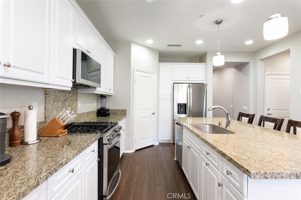25451 Jack Rabbit Lane Corona, CA 92883 - Photo 14 of 75 a kitchen with stainless steel appliances granite countertop a sink stove and refrigerator