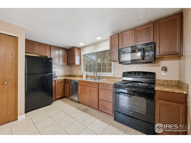 a kitchen with stainless steel appliances granite countertop a refrigerator stove top oven a sink and dishwasher