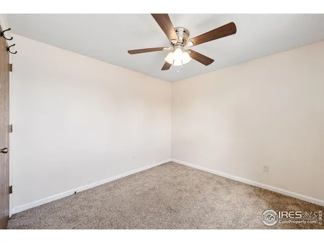 an empty room with a ceiling fan and wooden floor