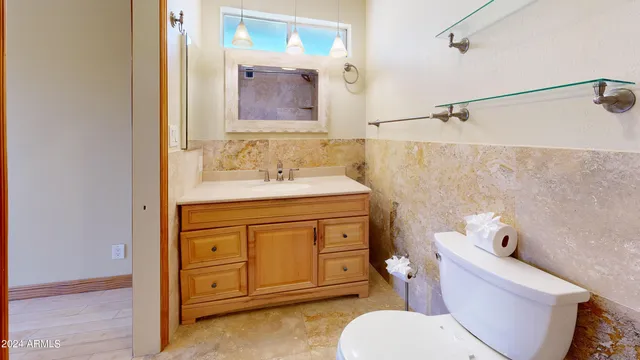 a bathroom with a sink vanity mirror and toilet