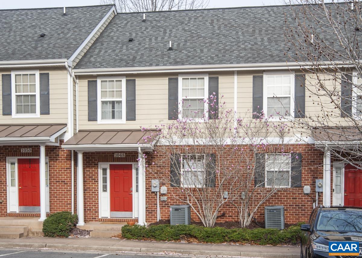 front view of a brick house with a fountain
