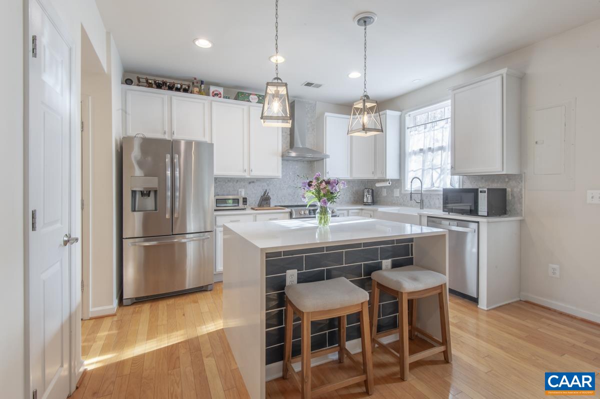 1048 5th Street Southwest Charlottesville, VA 22902 - Photo 11 of 36 a kitchen with refrigerator a sink and chairs