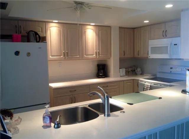 a kitchen with kitchen island granite countertop a sink stainless steel appliances and cabinets
