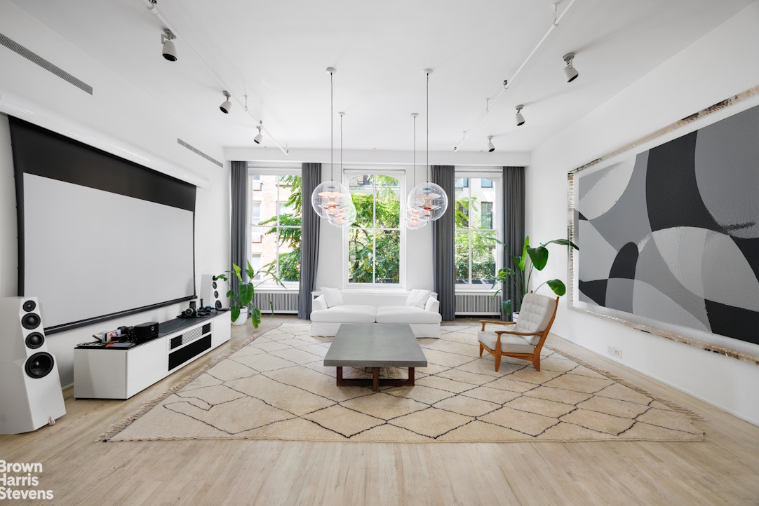 a living room with furniture gym equipment and large window