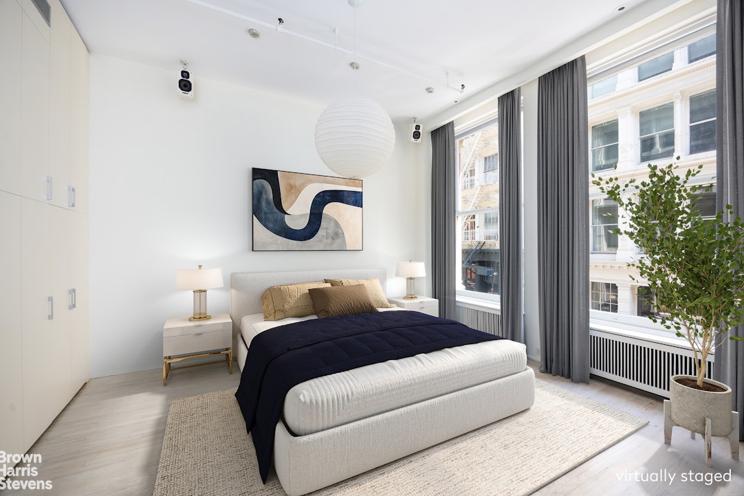 129 Greene Street, Unit 2 Manhattan, NY 10012 - Photo 9 of 12 a bedroom with a bed and a large window