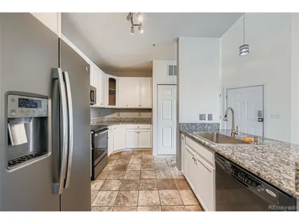a kitchen with stainless steel appliances granite countertop a refrigerator stove and sink