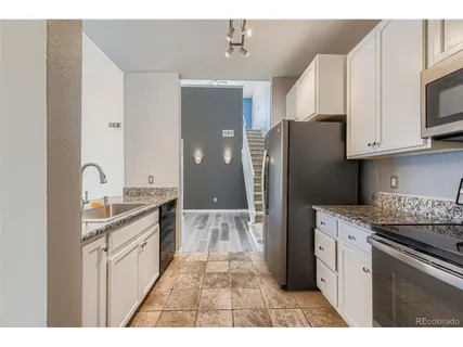 a kitchen with white cabinets and sink