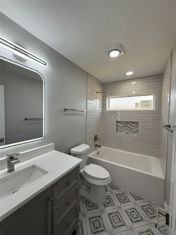 a bathroom with a sink a toilet a mirror and bathtub