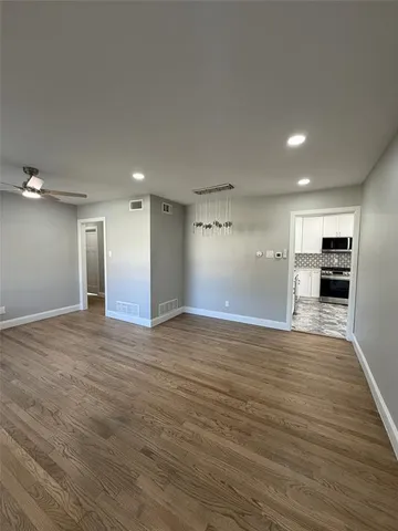 a view of empty room with wooden floor