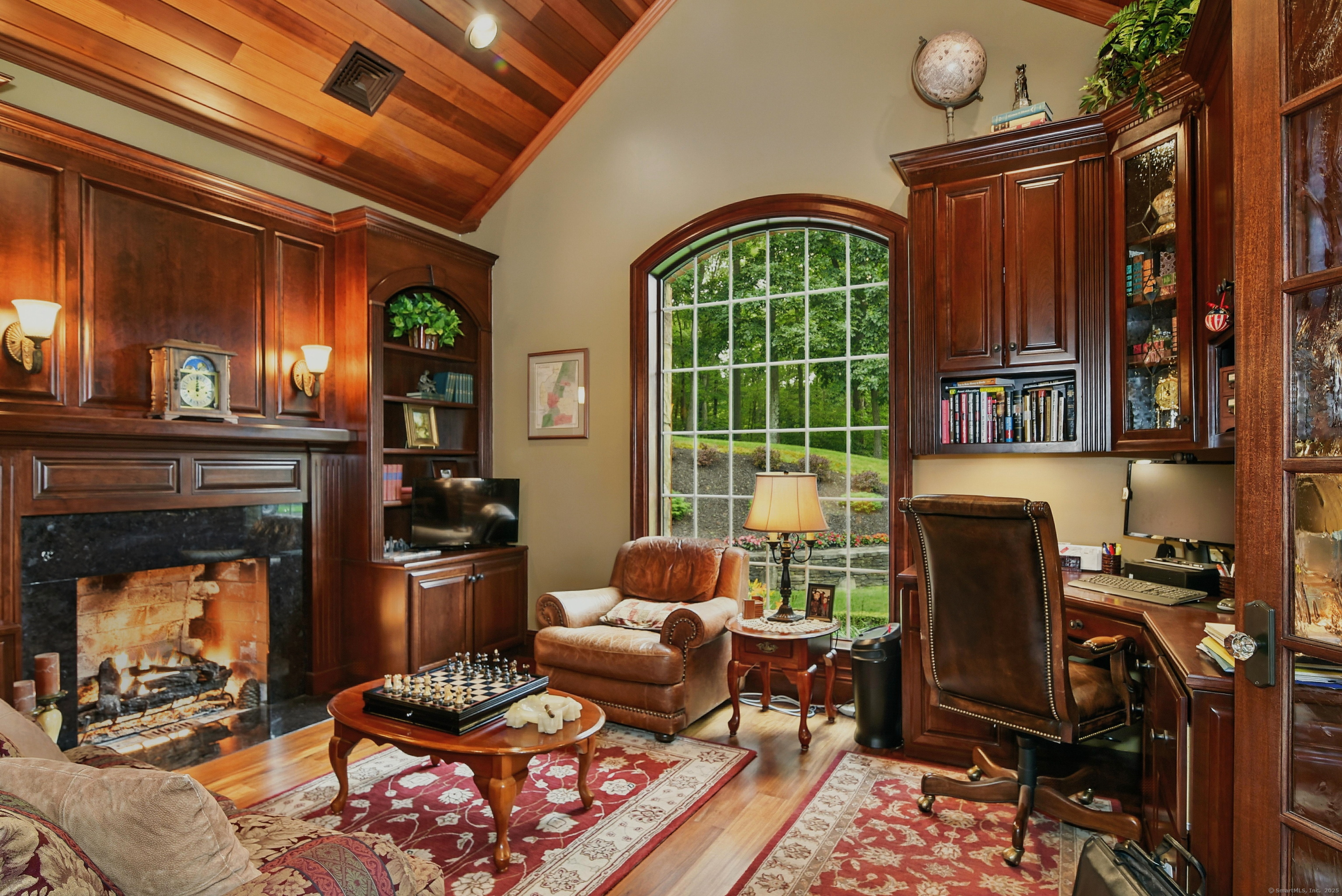 282 Searles Road Pomfret, CT 06259 - Photo 3 of 40 Office is distinguished by 15-foot vaulted California Redwood ceiling trimmed with custom milled redwood crown molding. Oversized arched window provides garden views next to the built-in executive desk with custom cabinetry.