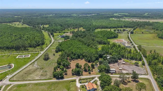an aerial view of a house with a garden and lake view