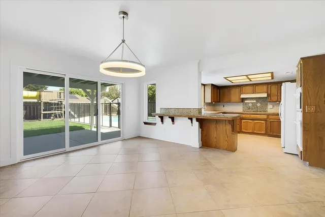 a view of empty room with wooden floor and ceiling fan