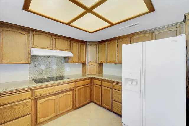 an empty room with a fan & a window