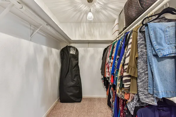 a view of walk in closet with clothes