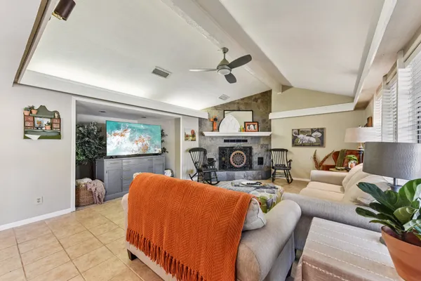a living room with furniture a fireplace and a flat screen tv