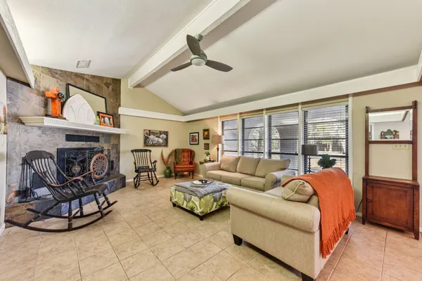 a living room with furniture a fireplace and a large window