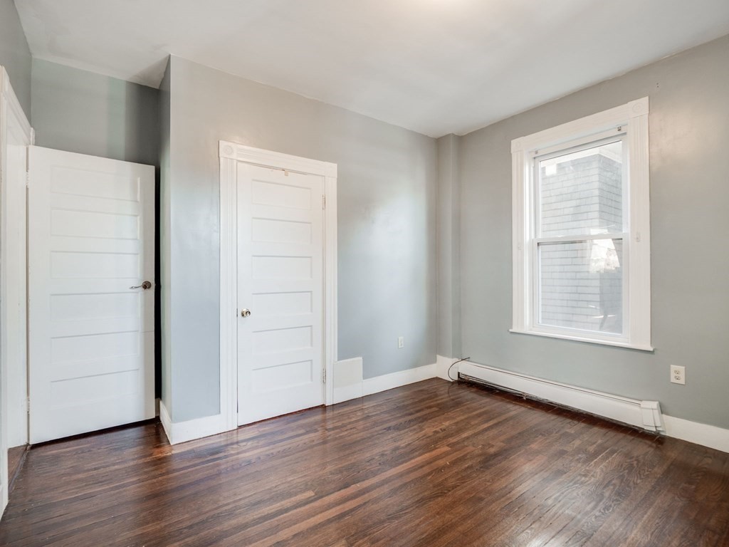 38 Cherry Street, Unit 2 Lynn, MA 01902 - Photo 27 of 40 an empty room with wooden floor closet and windows