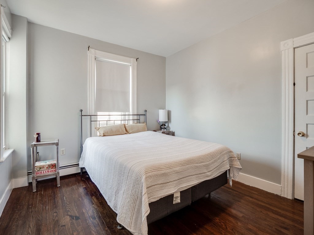 38 Cherry Street, Unit 2 Lynn, MA 01902 - Photo 30 of 40 a bedroom with a bed and wooden floor