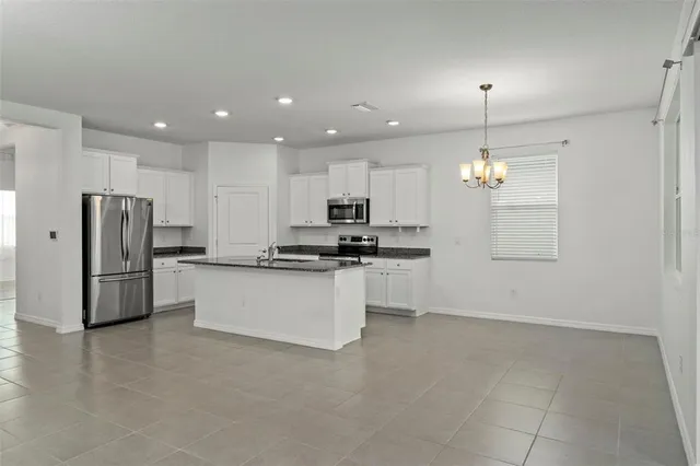 a view of a kitchen with stainless steel appliances granite countertop a stove and a sink