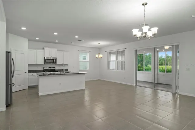 a large white kitchen with a refrigerator a stove and a sink