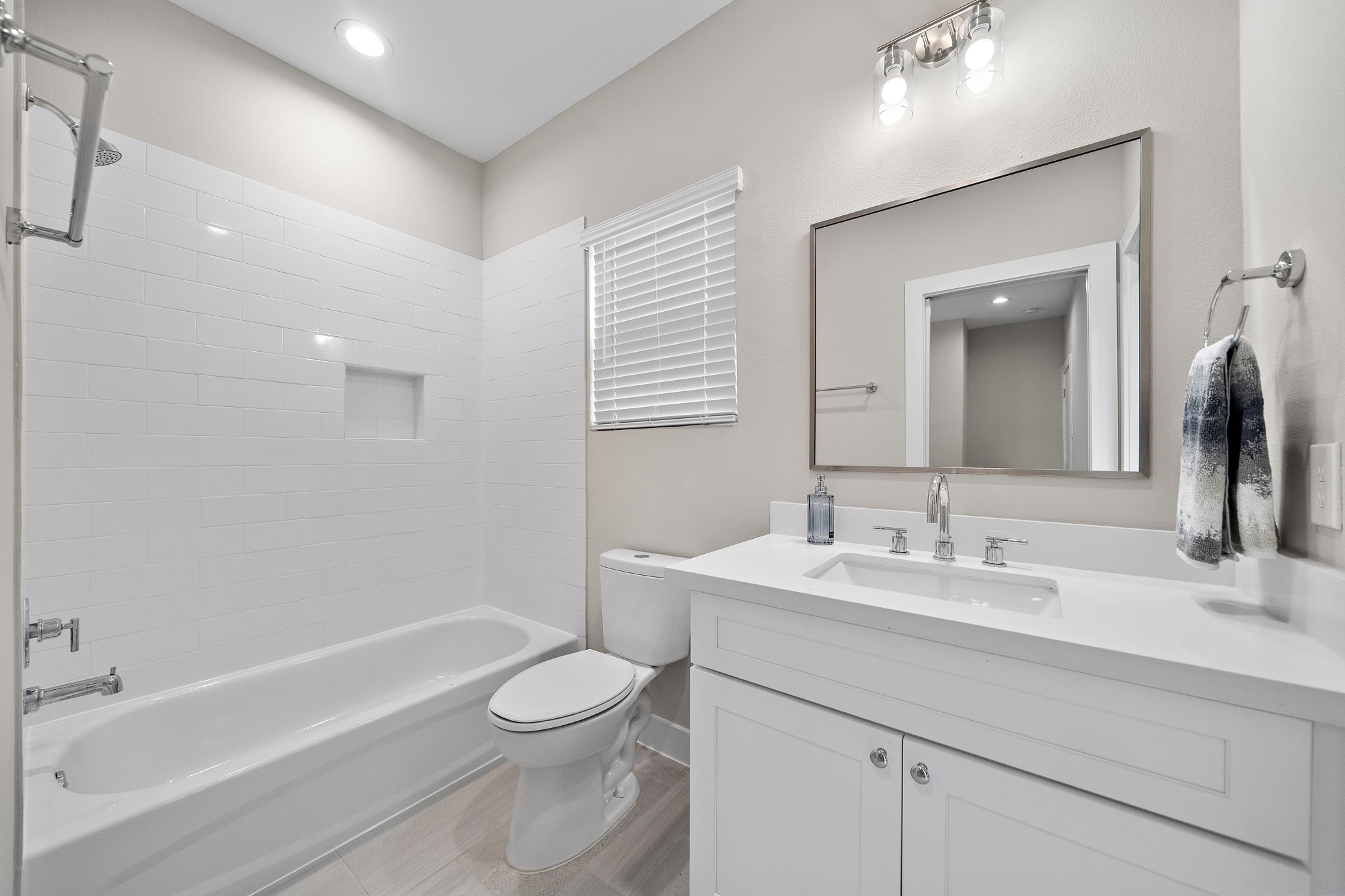 7510 Sandle Street Houston, TX 77088 - Photo 11 of 26 a bathroom with a toilet a sink a mirror a bathtub and vanity