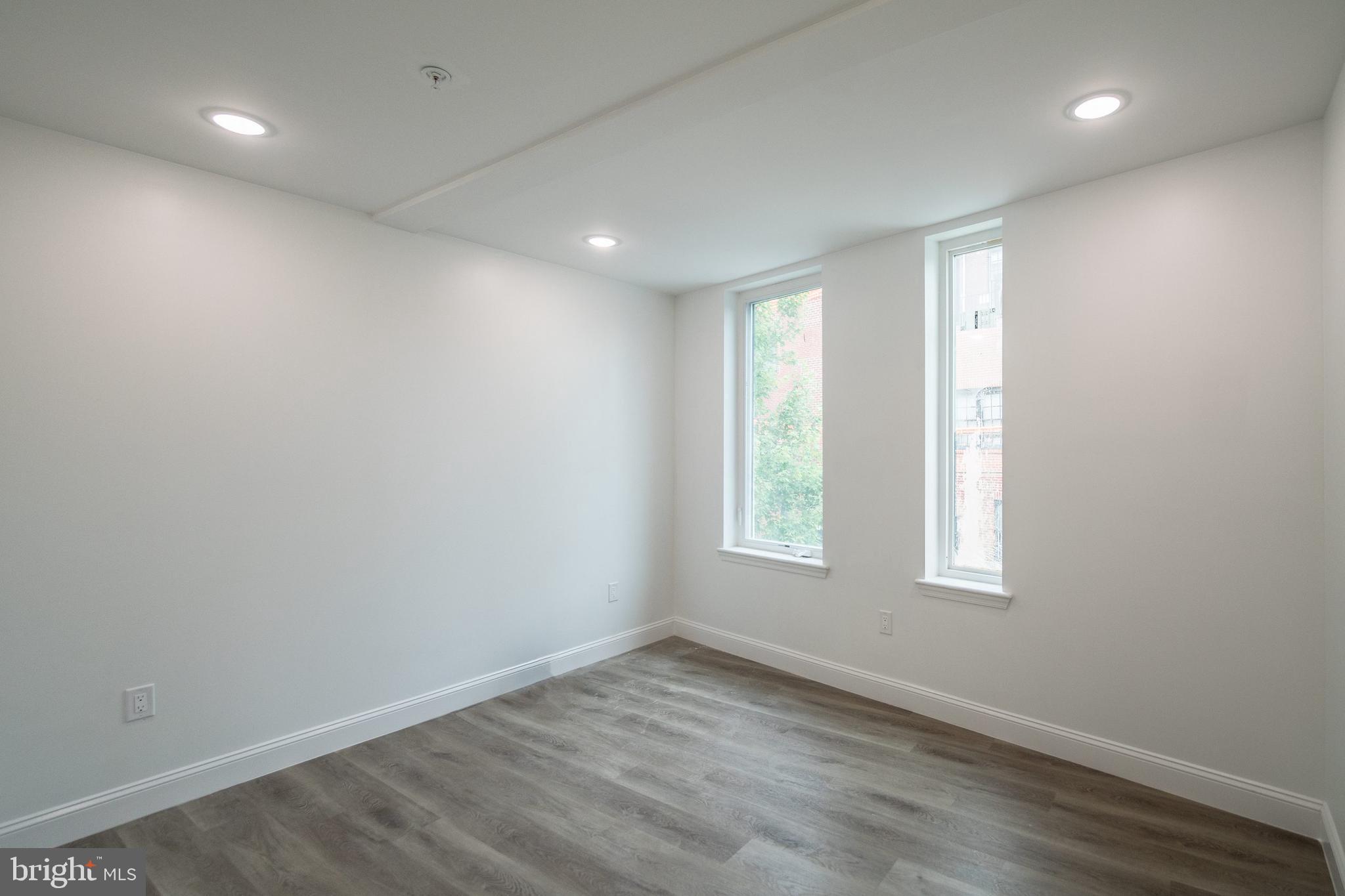 129 Washington Avenue, Unit B Philadelphia, PA 19147 - Photo 13 of 18 an empty room with wooden floor and windows