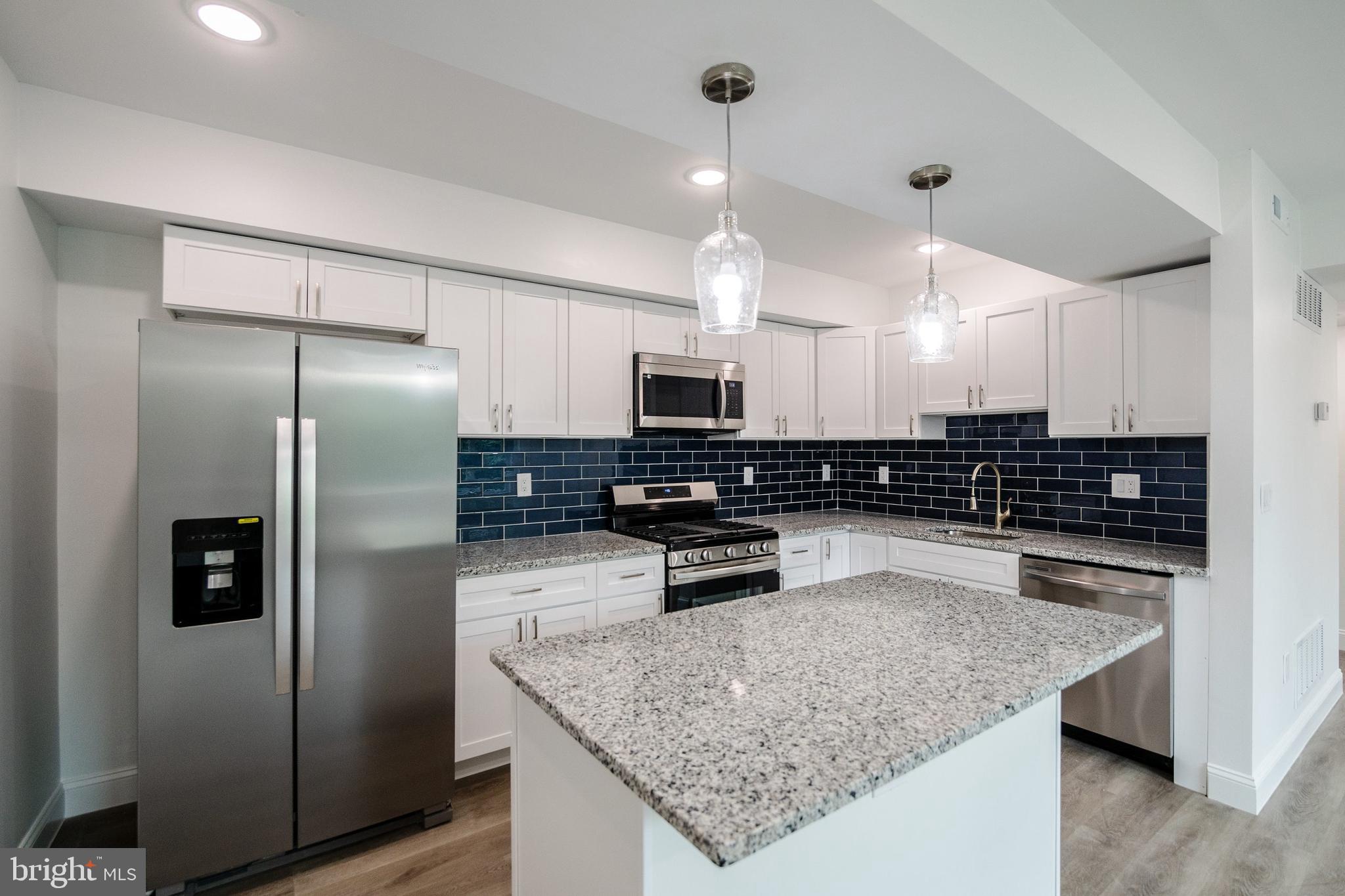 129 Washington Avenue, Unit B Philadelphia, PA 19147 - Photo 3 of 18 a kitchen with stainless steel appliances granite countertop a sink refrigerator and microwave