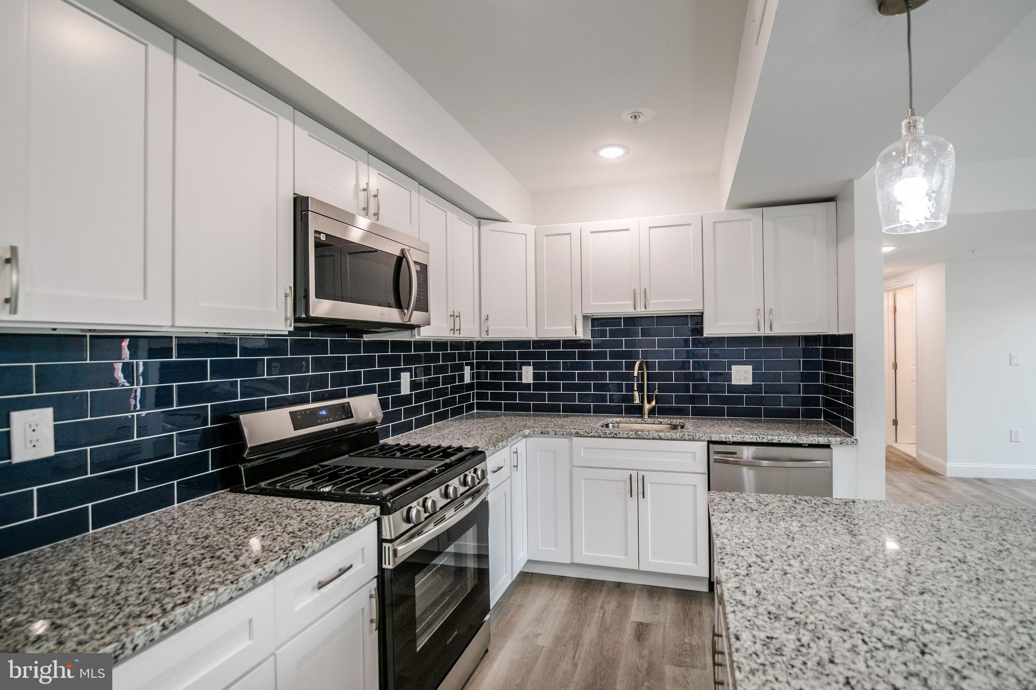 129 Washington Avenue, Unit B Philadelphia, PA 19147 - Photo 5 of 18 a kitchen with stainless steel appliances granite countertop a stove and a sink
