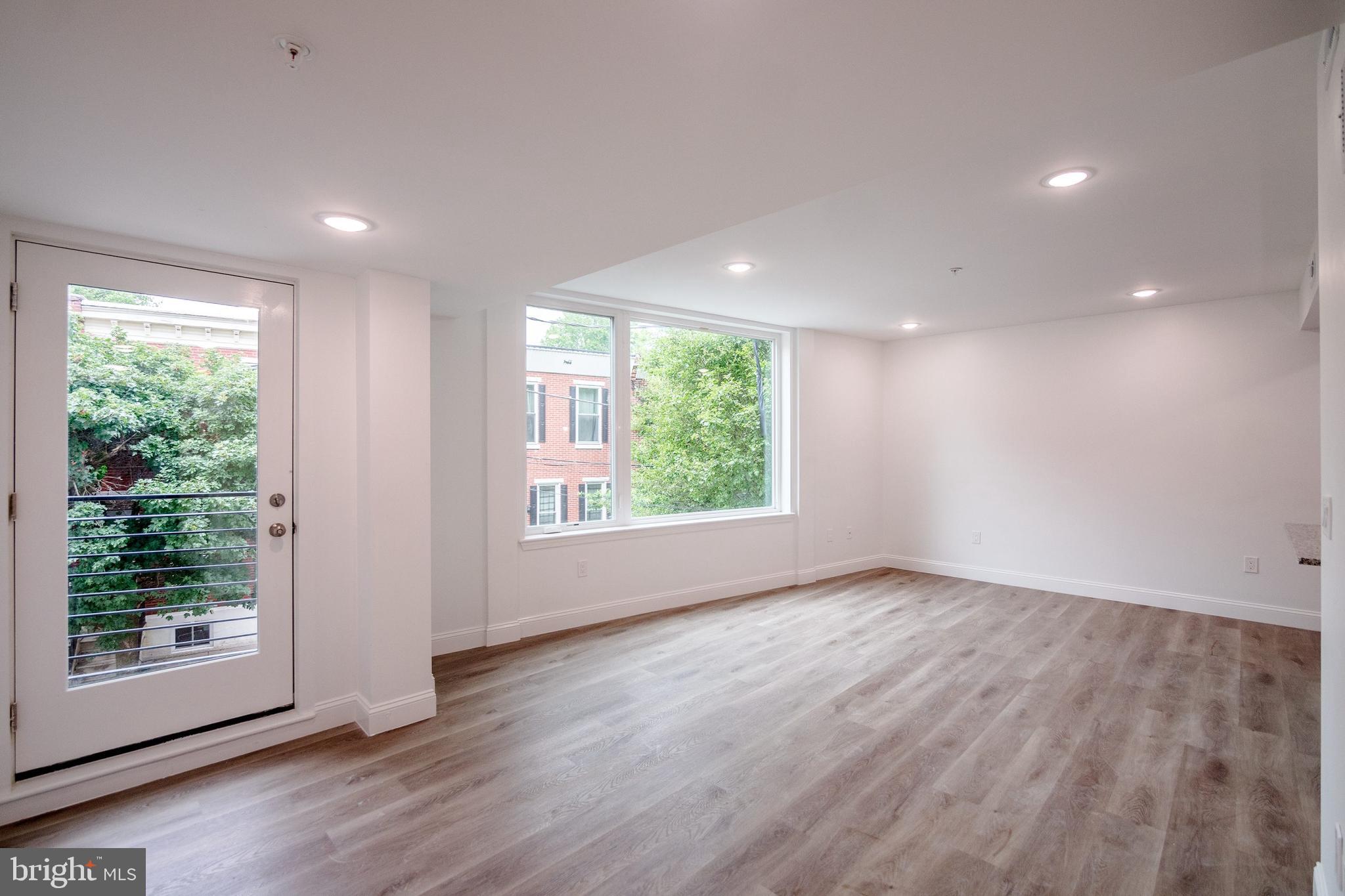 129 Washington Avenue, Unit B Philadelphia, PA 19147 - Photo 6 of 18 a view of an empty room with wooden floor and a window