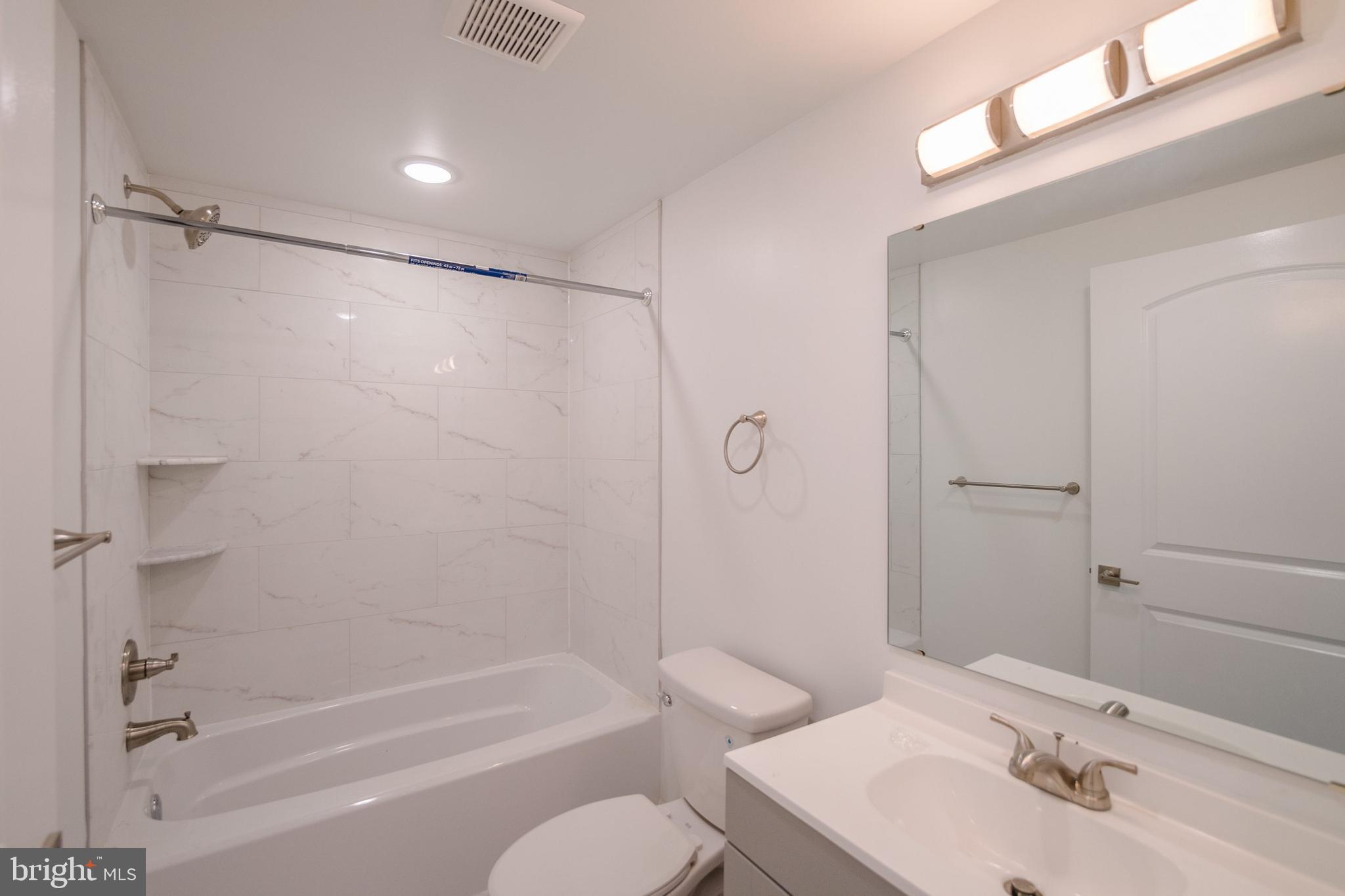 129 Washington Avenue, Unit B Philadelphia, PA 19147 - Photo 9 of 18 a bathroom with a bathtub shower sink vanity and toilet