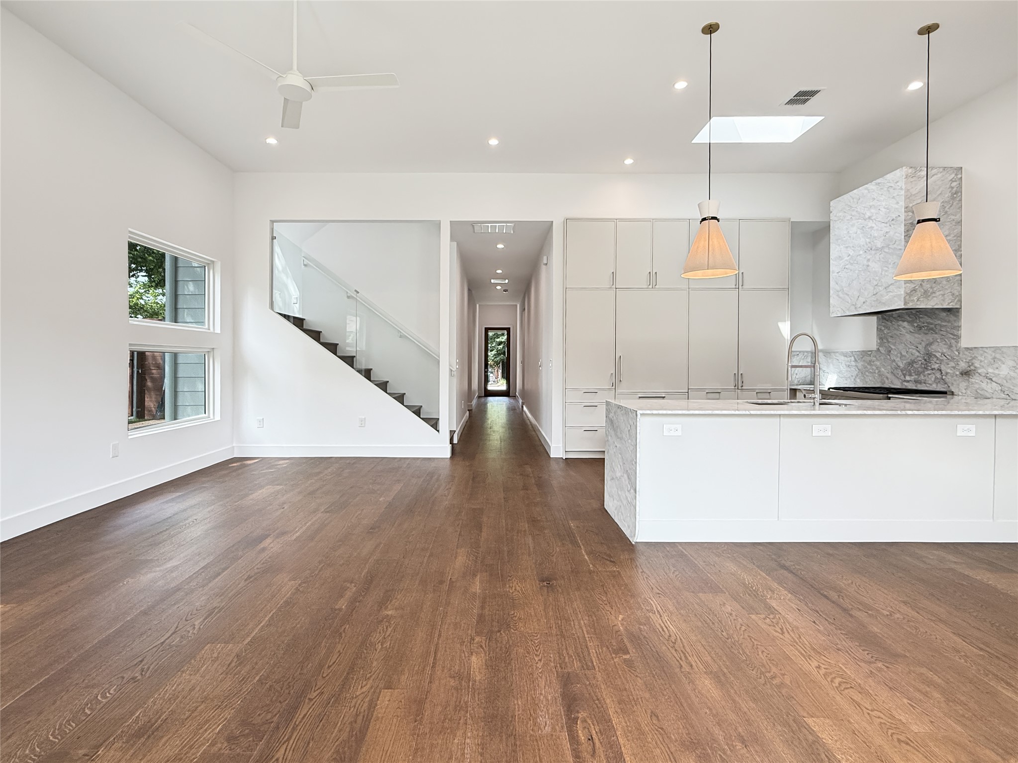 127 Frederick Street Austin, TX 78704 - Photo 5 of 34 Open-concept living space featuring wood-finish flooring, a contemporary kitchen, and a modern staircase